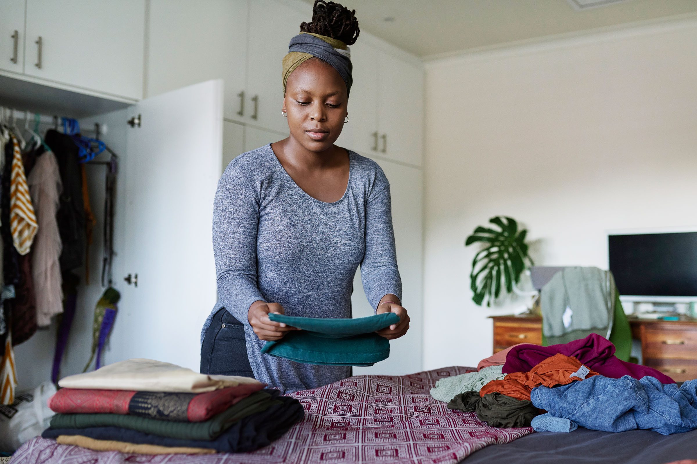 woman folding clothes and organizing her closet at home