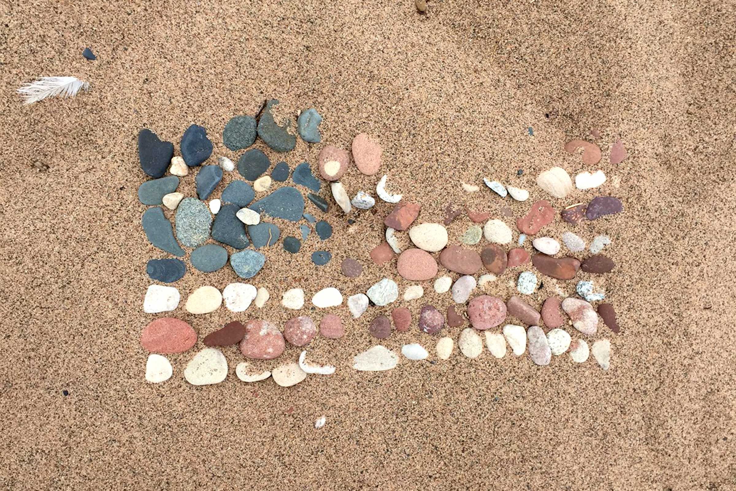 an array of rocks in the sand along the Wisconsin shore of Lake Superior create the image of an american flag