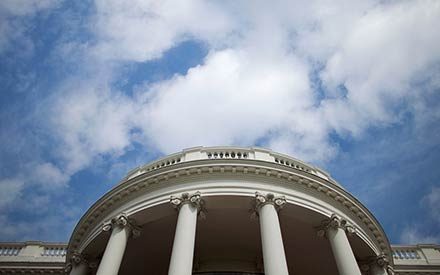 White House below a blue sky with clouds