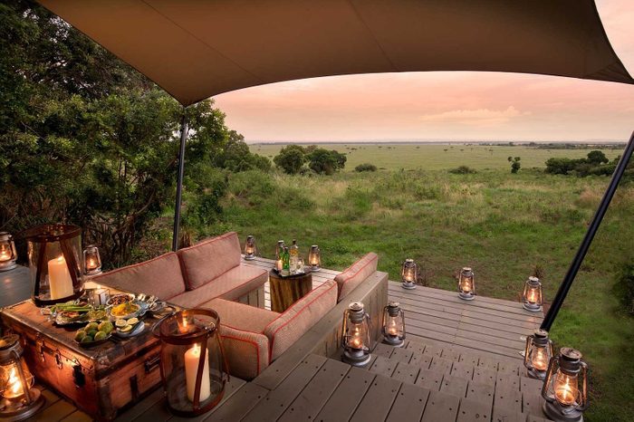 sitting area with candles at dusk looking out at safari at Bateleur Camp Via Tripadvisor.com
