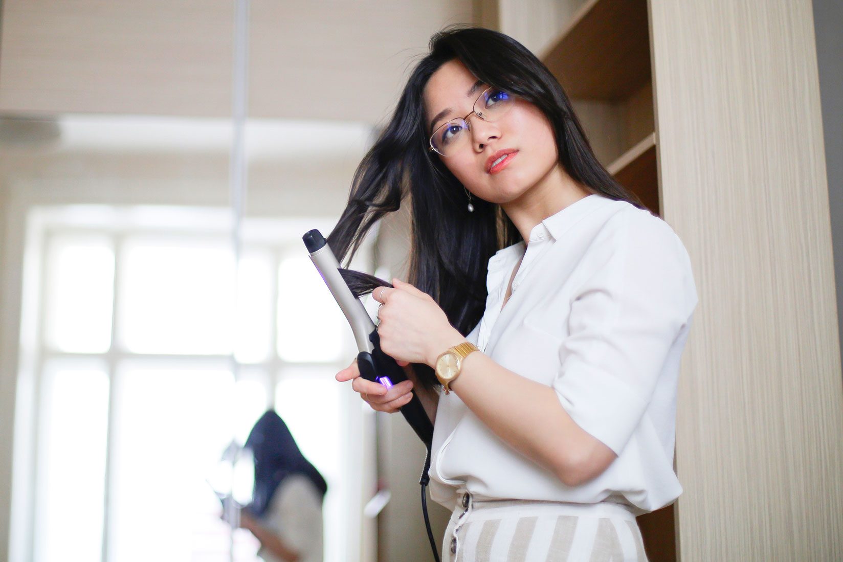 woman using curling iron