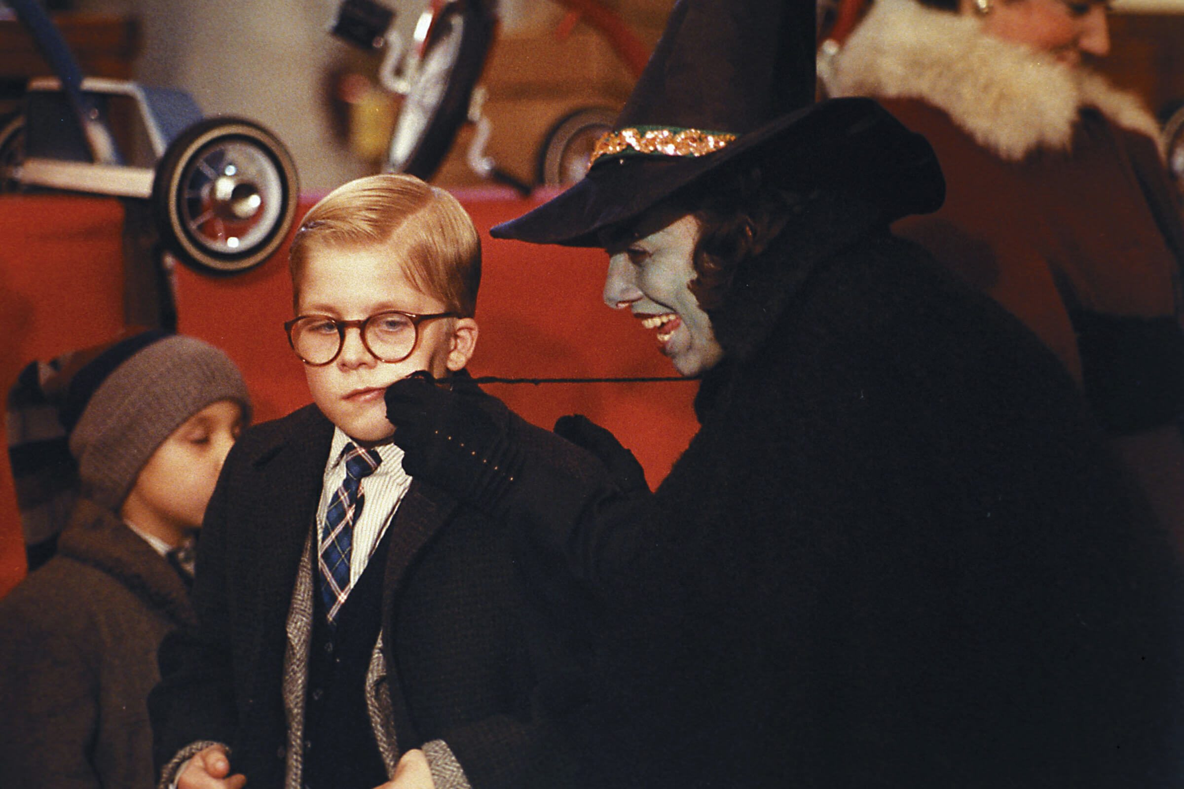 A scene from A Christmas Story of a young boy getting his cheeks pinched by a witch