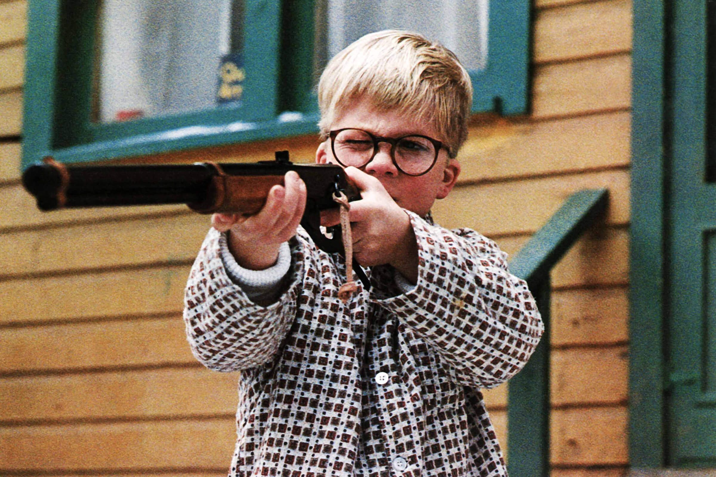 A scene from A Christmas Story of a young boy holding a gun