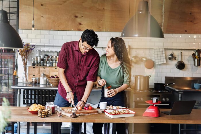 couple cooking dinner at home together smiling