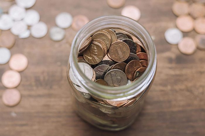 coin jar filled with savings on wood table