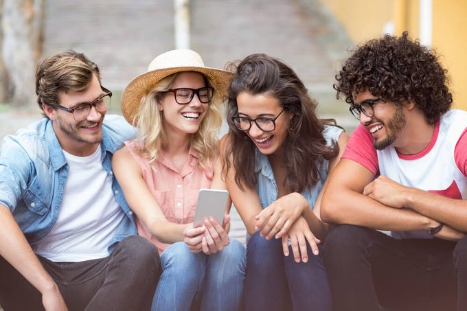 Group of friends interacting using mobile phone