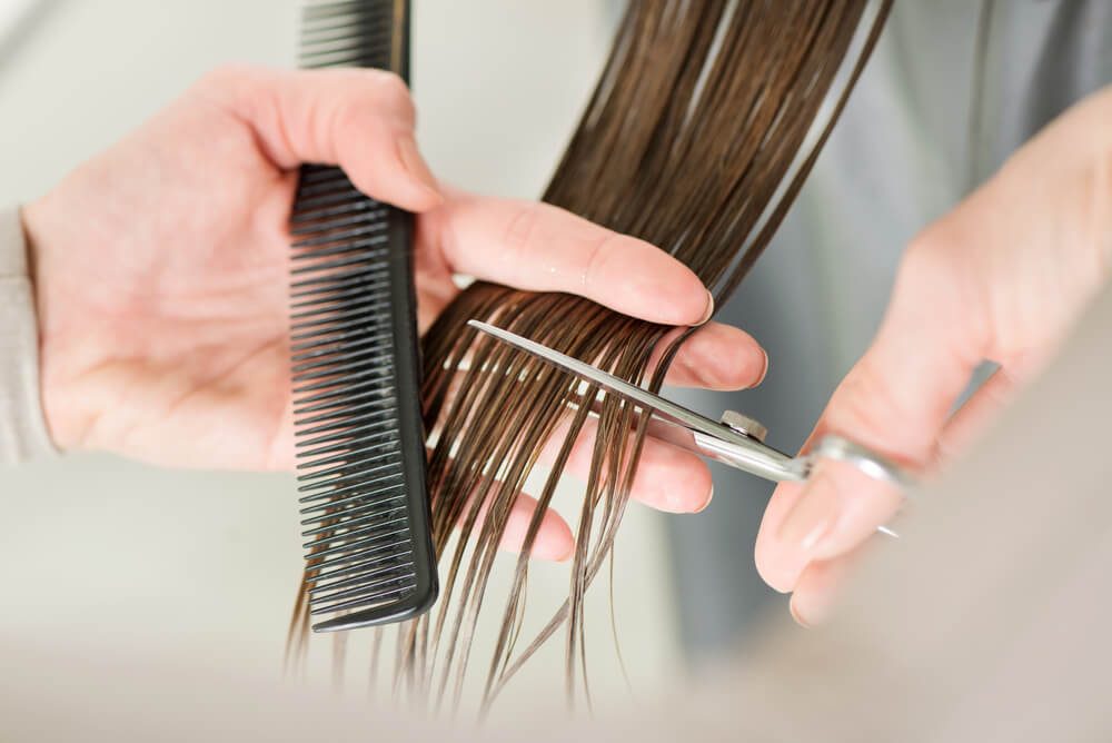 Hairdresser cut hair of a woman. Close-up. 