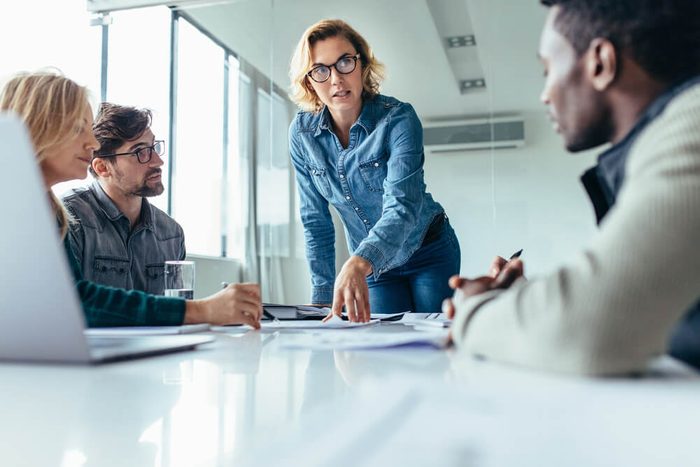 Businesswoman standing and leading business presentation. Female executive putting her ideas during presentation in conference room.