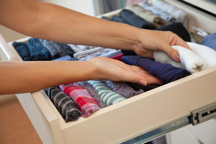 The drawer with underwear in the closet. Men's Clothing lying in the locker room. The order in the men's wardrobe.