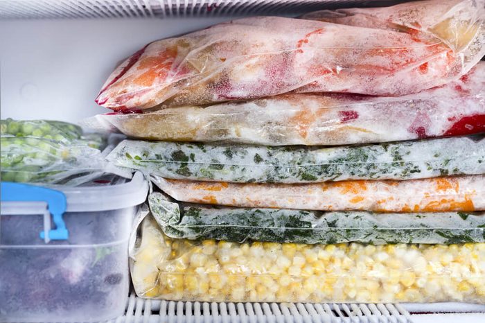 Frozen berries and vegetables in bags in freezer close up