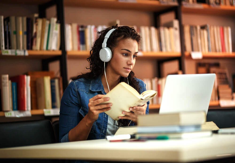 Young female student study in the school library.She using laptop and learning online.