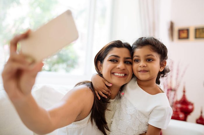 Smiling mother and daughter bonding together to take a selfie