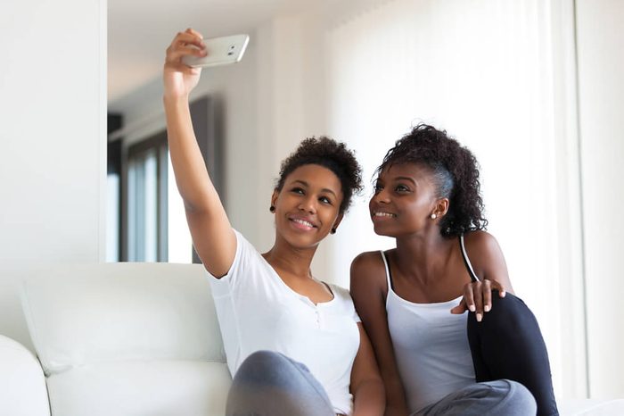 African American teenage girls taking a selfie picture with a smartphone