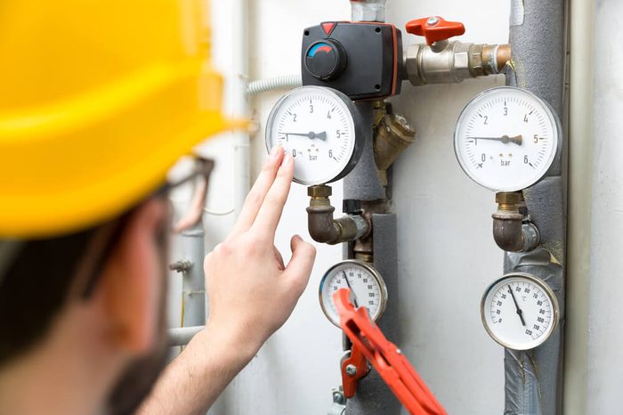 maintenance - technician checking pressure meters for house heating system