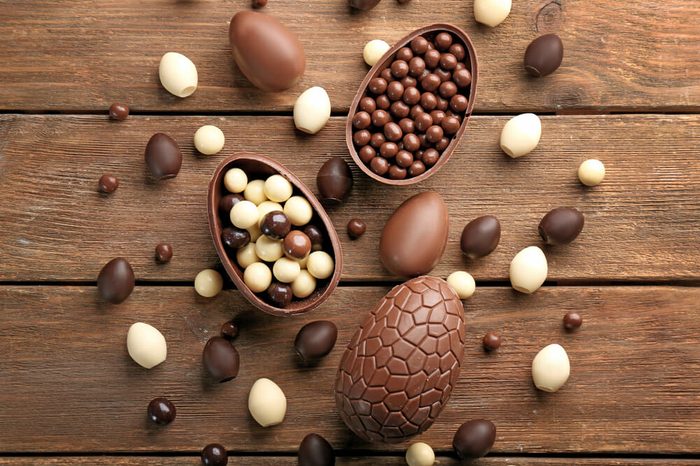 Chocolate Easter eggs and sweets on brown wooden background