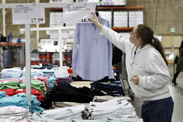 A Costco worker changes the price sign at Costco in Mountain View, Calif. Businesses trimmed inventories at the wholesale level again in January even though sales rose for a 10th consecutive month. The dip in inventories underscored that businesses remain cautious about restocking their depleted shelves