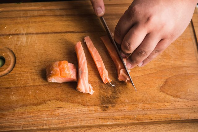 Sushi chef cutting fish