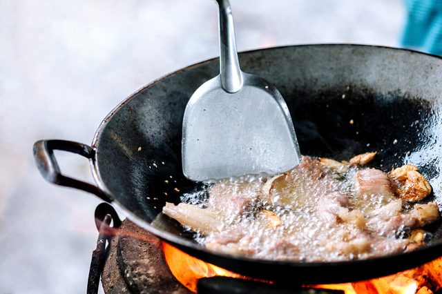 fried pork cooking on stove in outdoor poor kitchen of camping