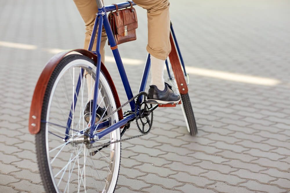 people, style and lifestyle - close up of hipster man riding fixed gear bike on city street