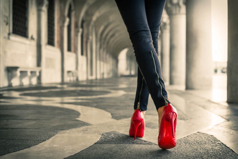 Woman in black leather pants and red high heel shoes