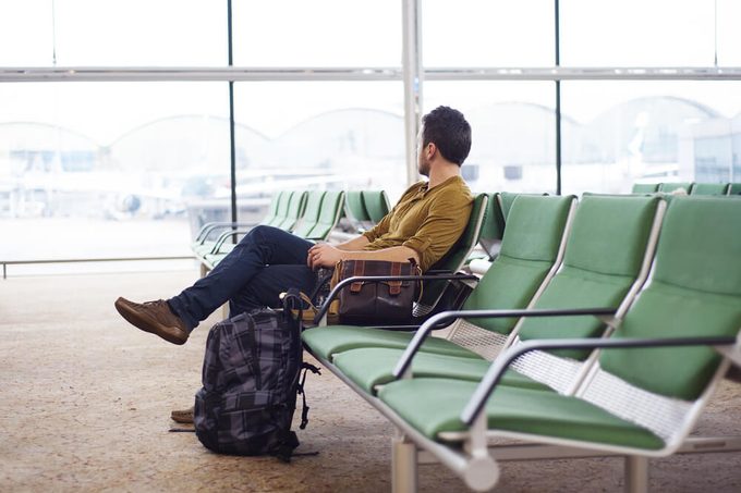 Young man at the airport waiting for his plane