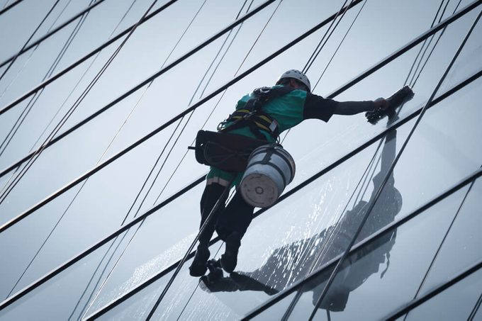 group of workers cleaning windows service on high rise building