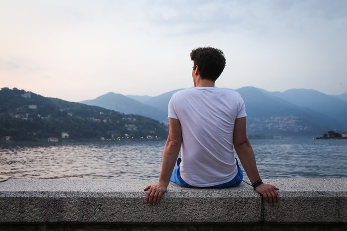 The young man looking at the beautiful view at the lake