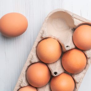 fresh brown eggs in carton on counter