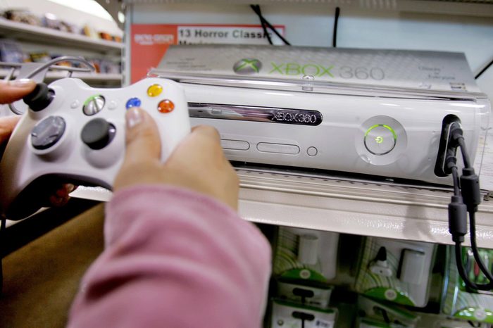 CENTER Christine Canasa plays a game using the new Xbox 360 game console at Micro Center computer store in Santa Clara, Calif., . bWith enough hardware horsepower to deliver movie-like graphics and high-quality sound, Microsoft Corp.'s Xbox 360 is setting a new standard for video games. But the console isn't just about shoot-'em-ups and virtual sports. Like its predecessor, the 360 can serve as an "extender" to a PC running Microsoft's Windows XP Media Center Edition 2005 operating system. Nearly every type of media that plays on the PC can be piped _ wired or wirelessly _ over a home network and through the Xbox to a TV. This time, the feature is built into the console (both the $300 and $400 versions) and doesn't require the purchase of additional software. It also can handle the demands of high-definition television without a hiccup