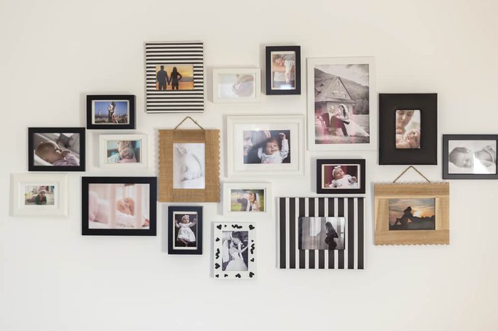 white wall with photos of the family in various photo frames