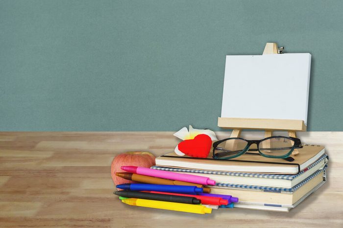 School, education, teacher's day and literacy concept with student and teacher stationery and supples on wood table over grey wall background