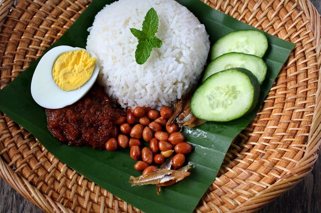 Nasi Lemak-Malaysian cuisine.  A fragrant rice dish cooked in coconut milk and pandan leaf commonly found in Malaysia. Served with sambal, anchovies, peanut and cucumber.