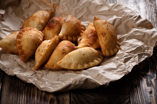 Fried colombian empanadas on wooden table. Savory stuffed patties also known as pastel,pate or pirozhki