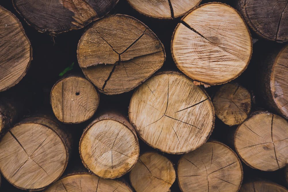 Natural wooden background - closeup of chopped firewood. Firewood stacked and prepared for winter Pile of wood logs