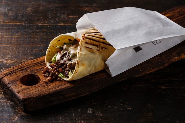 Doner Kebab Gyros Shawarma beef roll in pitta bread Wrap sandwich on wooden background