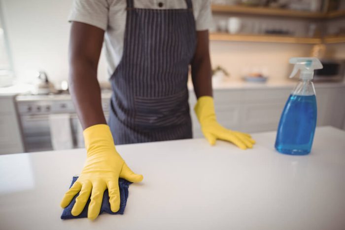 Mid section of man cleaning the kitchen worktop at home