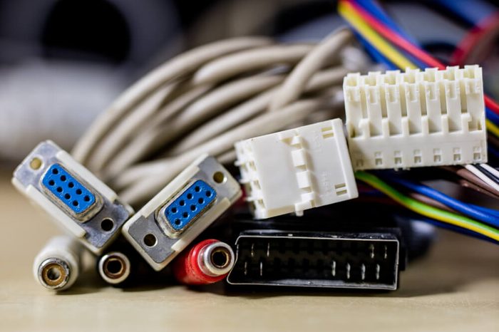 old computer wires. Cables lpt, com1 and com2 for desktop and laptop computers. Wooden table, black background.