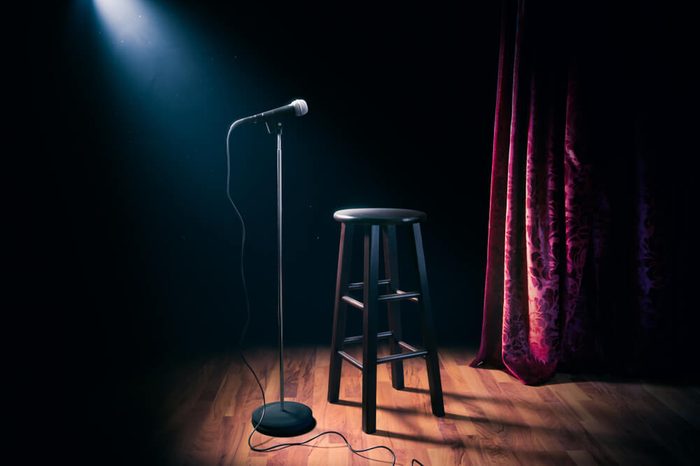 microphone and stool on a stand up comedy stage with reflectors ray, high contrast image