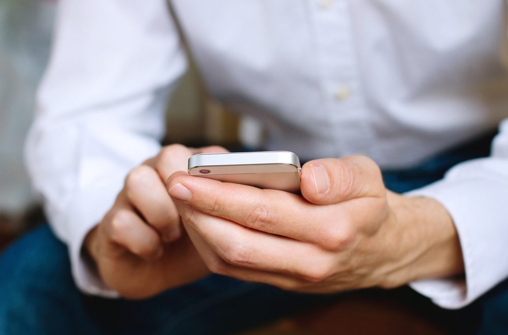 Close up of business man using mobile smart phone