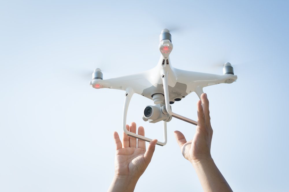 The drone and photographer man hands , The drone with the professional camera takes pictures.