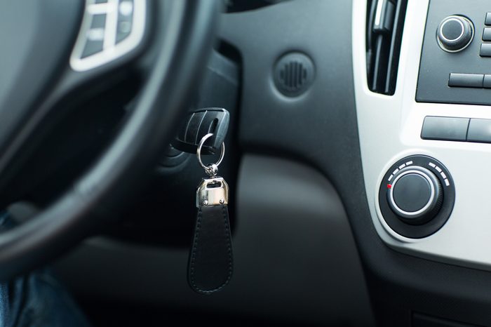 transportation and ownership concept - car key in ignition start lock