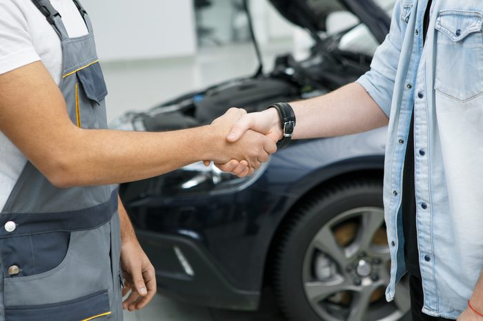 Cropped shot of a professional mechanic shaking hands with his client car on repair on the background partnership agreement deal service people gesture owner professionalism trust experience worker