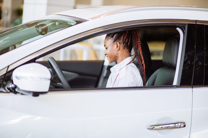 Pretty young woman leaning out of car window