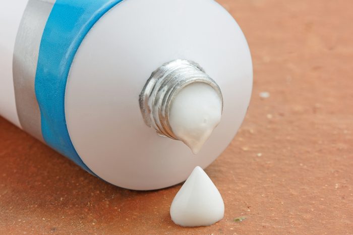 A tube of generic ointment or cream with a droplet squeezed out