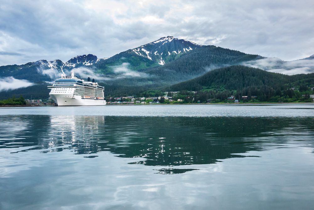 Cruise ship at a port in Juneau, Alaska with snow capped mountain and low lying fog in the background