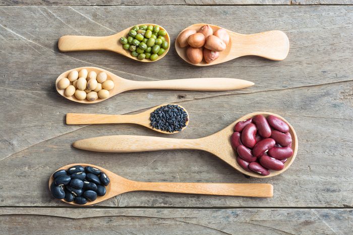 Group of beans and lentils in spoon made wood on wodden background. mung bean, groundnut, blackbean, black seasame, red kidney bean