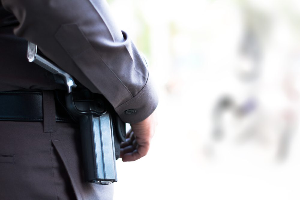 The side of policeman with gun.