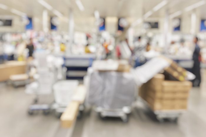 Blurred image of businesswoman is going to finding furniture for her business home with shopping mall cart in house and hardware department store background, store shopping mall background.