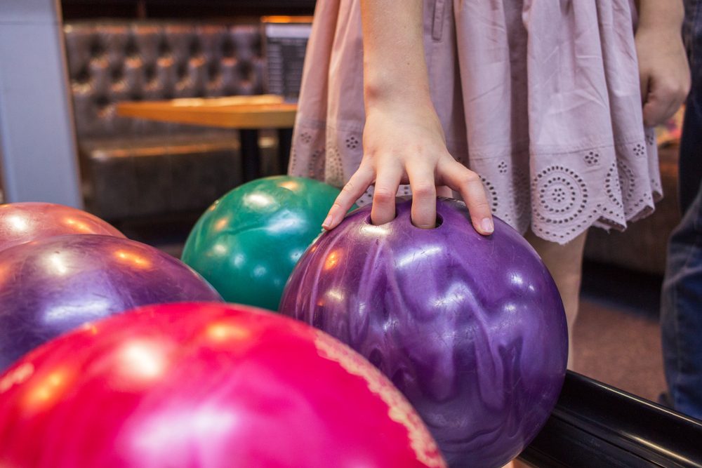 Girl holding bowl colorful variety game indoor.