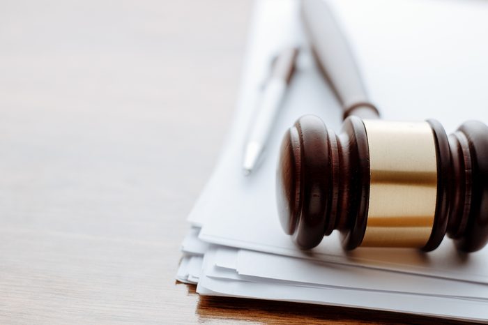 Gavel, ball pen and paper for notes lie on the wooden desk.